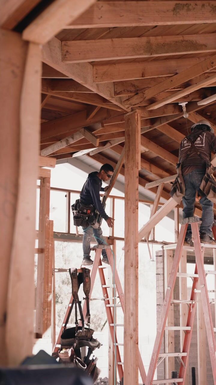 Framing crew working on ladders under the roof structure at 5507 E Pinchot in Arcadia