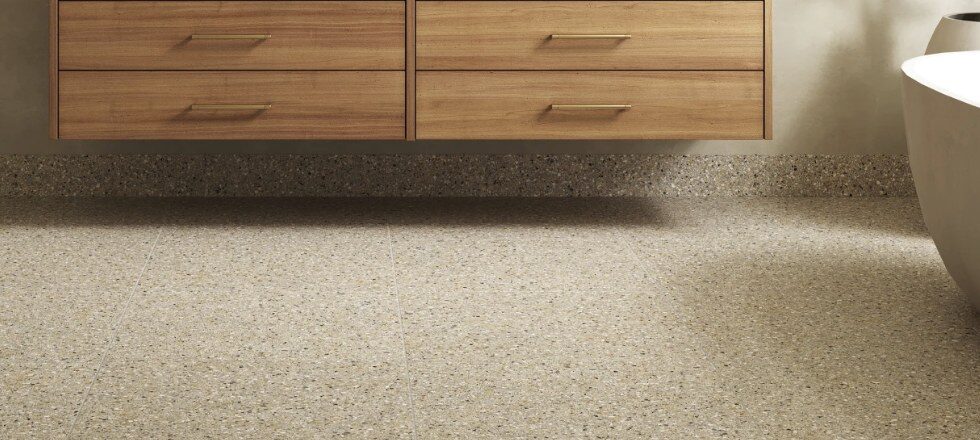 Reference photo of a speckled tile floor under floating wood cabinetry